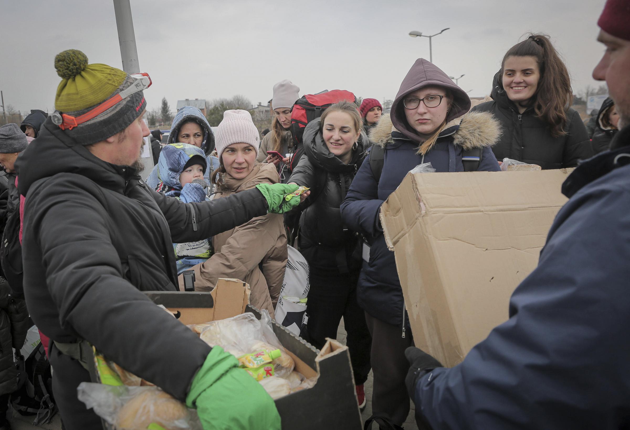 Volunteers give food and drinks to people, at the border crossing in Medyka, Poland. More than 1 million people have fled Ukraine following Russias invasion in the swiftest refugee exodus in this century, the United Nations said. 