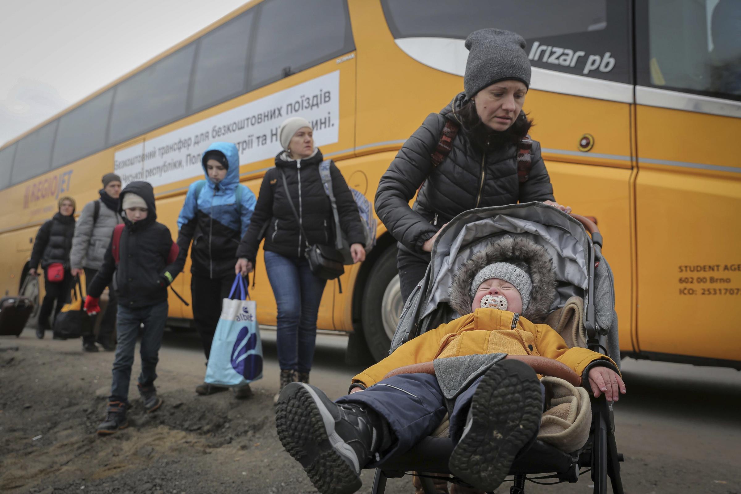 A woman pushes a stroller as people from Ukraine arrive at the border crossing in Medyka, Poland.