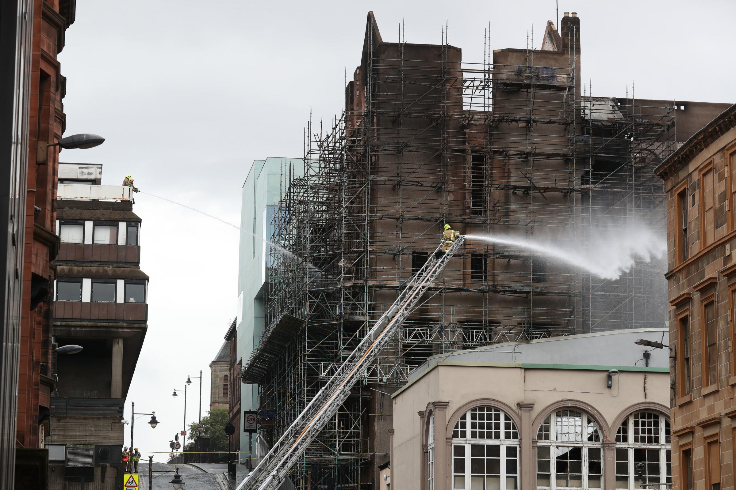 Firefighters dampening down following the fire at the Glasgow School of Art in 2018