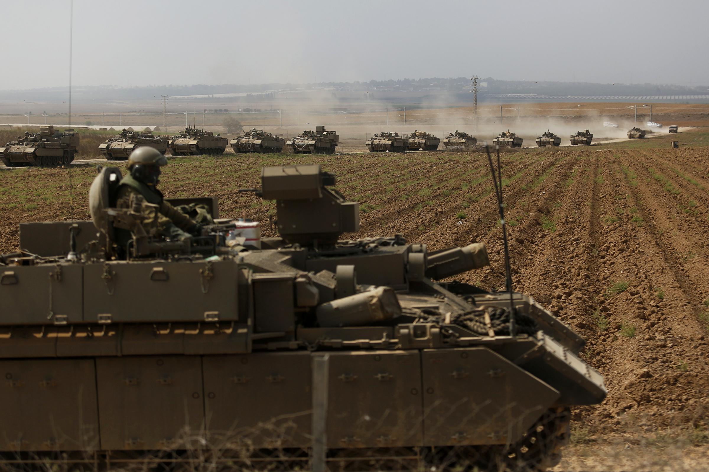 NEAR SDEROT, ISRAEL - OCTOBER 14: Tanks move in formation near the border with Gaza on October 14, 2023 near Sderot, Israel. Israel has sealed off Gaza and launched sustained retaliatory air strikes, which have killed at least 1,400 people with more than