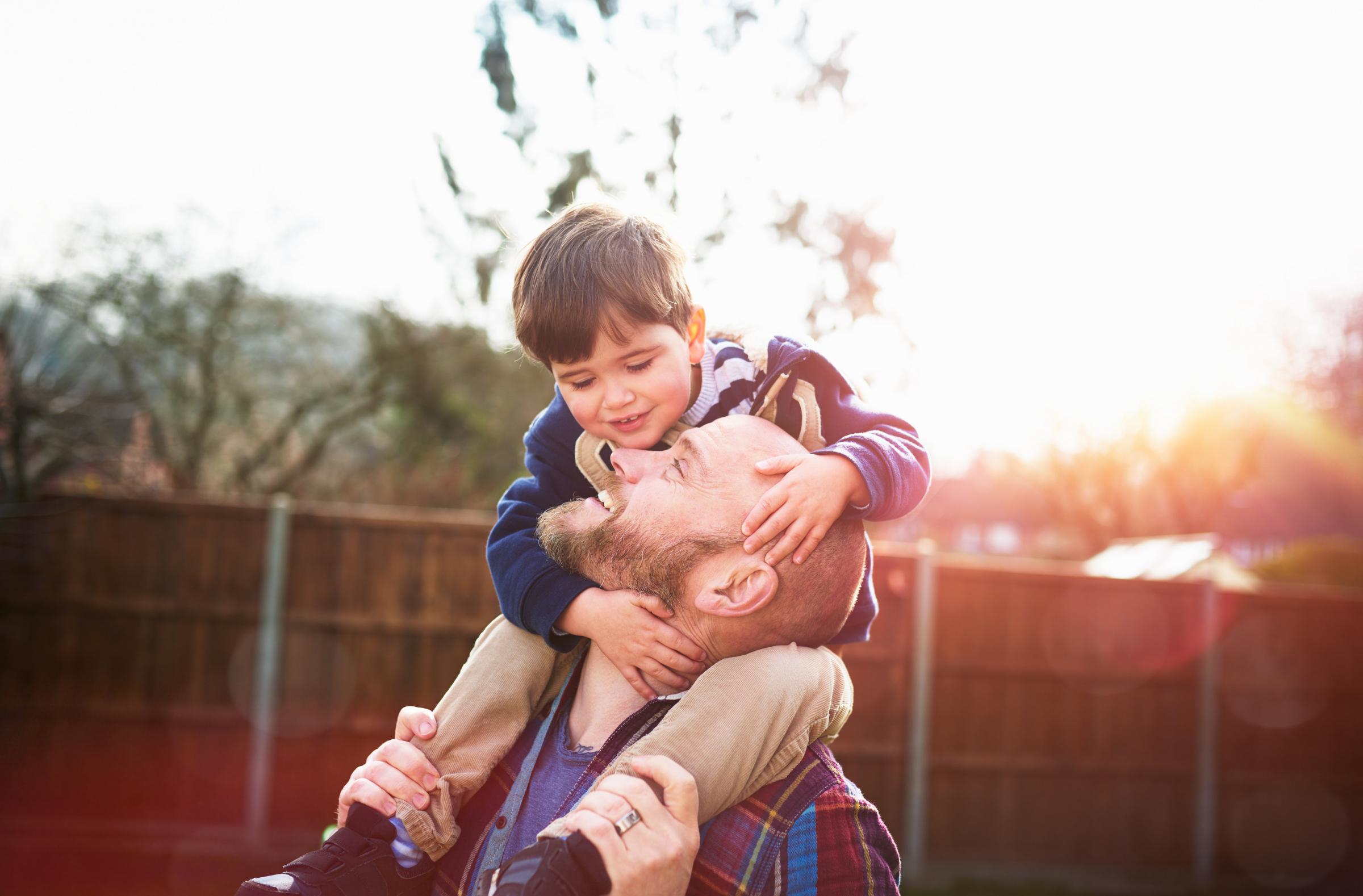 Son sitting on fathers shoulders.