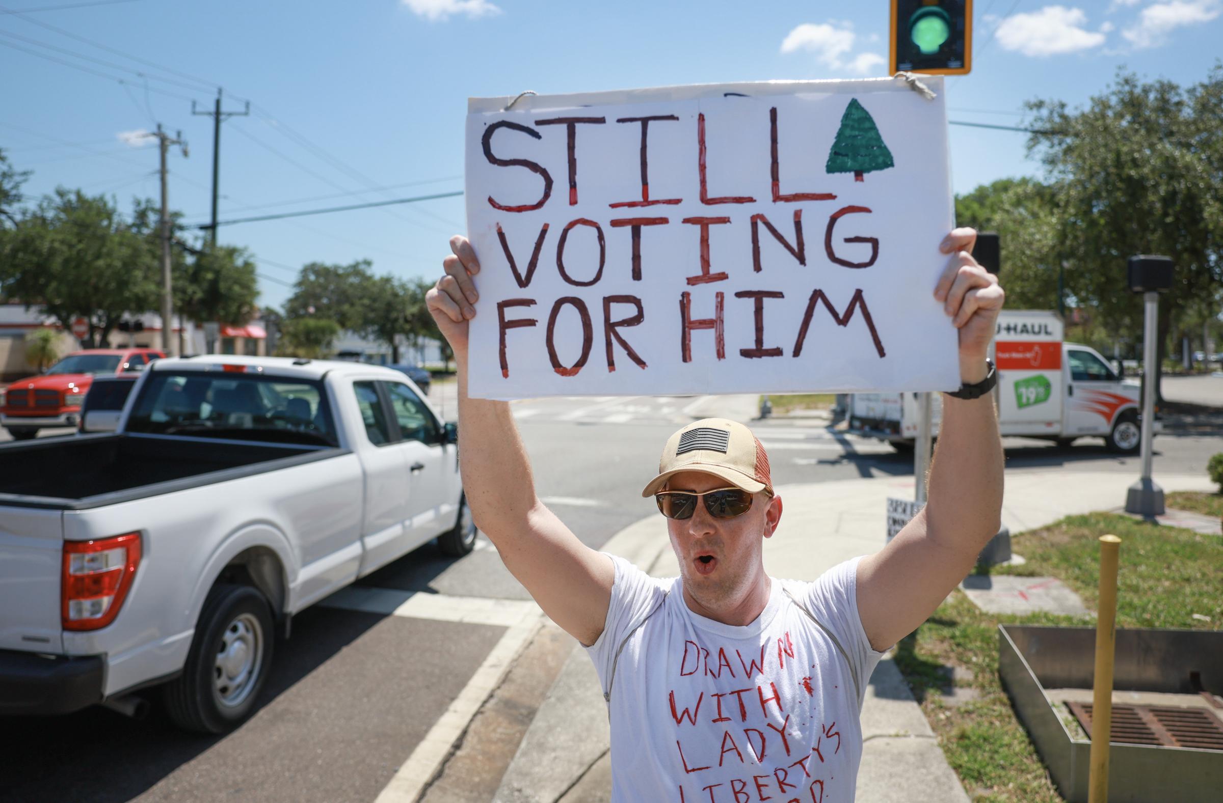 TITUSVILLE, FLORIDA - MAY 31: Mark Fuller, from Titusville, FL, holds a sign that reads, Still Voting for Him, as he shows his support for former President Donald Trump on May 31, 2024, in Titusville, Florida. Mr. Fuller said, that he knew that the