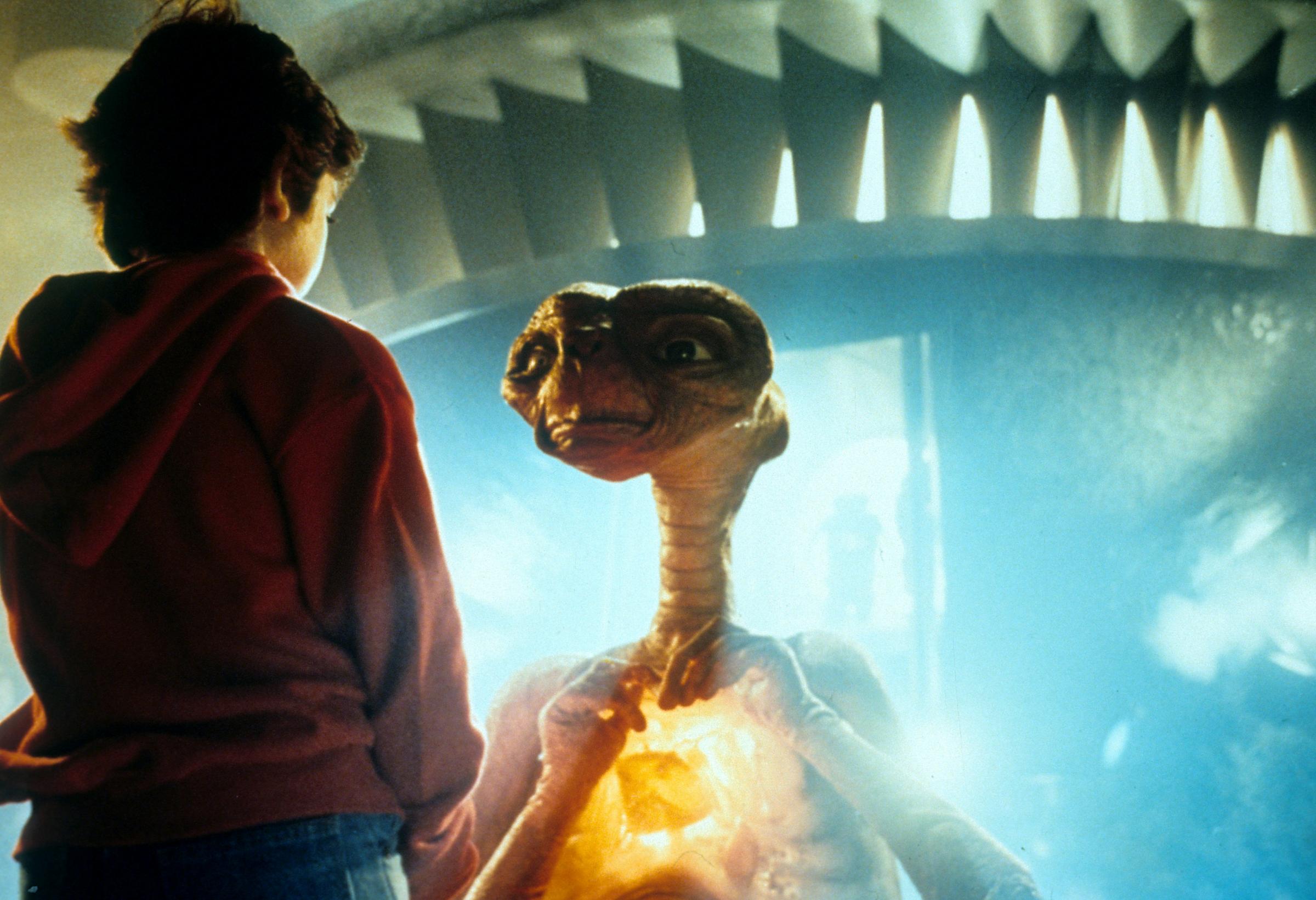 Henry Thomas talking with ET in a scene from the film E.T. The Extra-Terrestrial, 1982. (Photo by Universal/Getty Images).