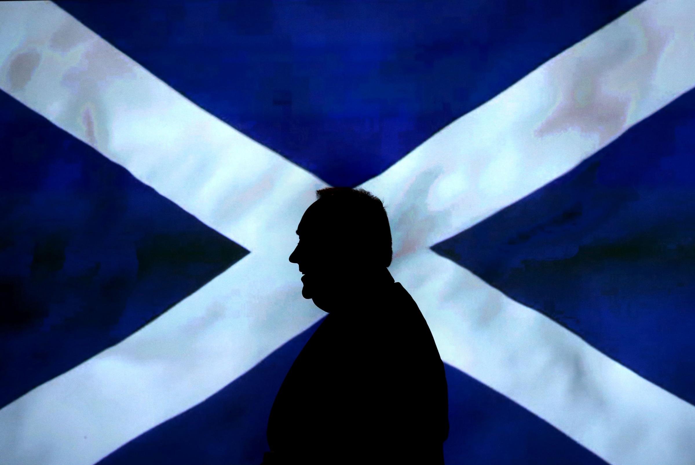 File photo dated 15/10/12 of Scottish First Minister Alex Salmond walking in front of a Saltire as aid cash from the UK could fall by £1 billion if Scotland becomes independent, a committee of MPs has warned. PRESS ASSOCIATION Photo. Issue date: