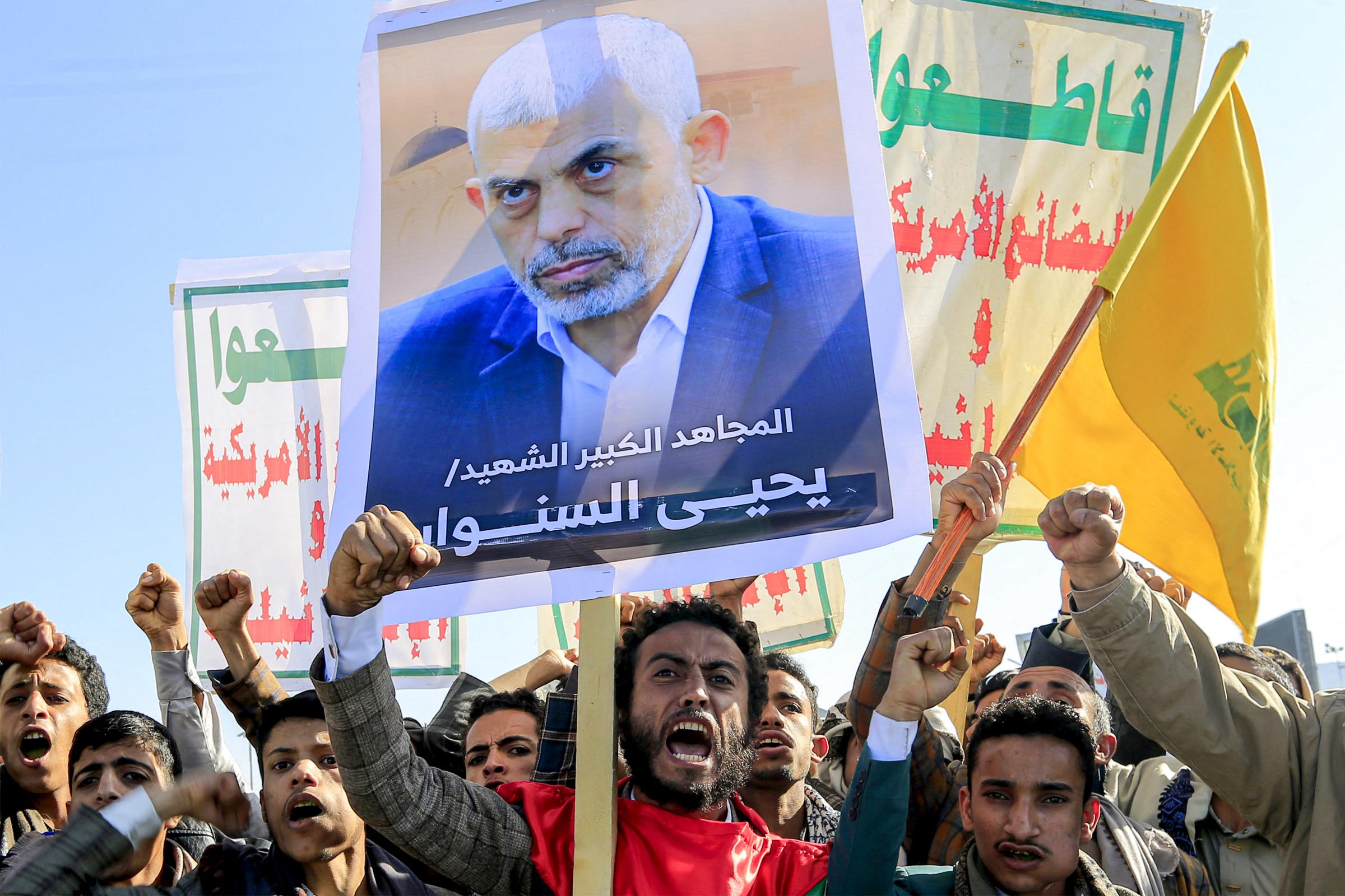 TOPSHOT - Supporters of Yemens Huthis chant slogans as they gather with a picture of Hamas slain leader Yahya Sinwar during a rally held in the Huthi-controlled capital Sanaa on October 18, 2024 in protest against Israels attacks on Lebanon and the