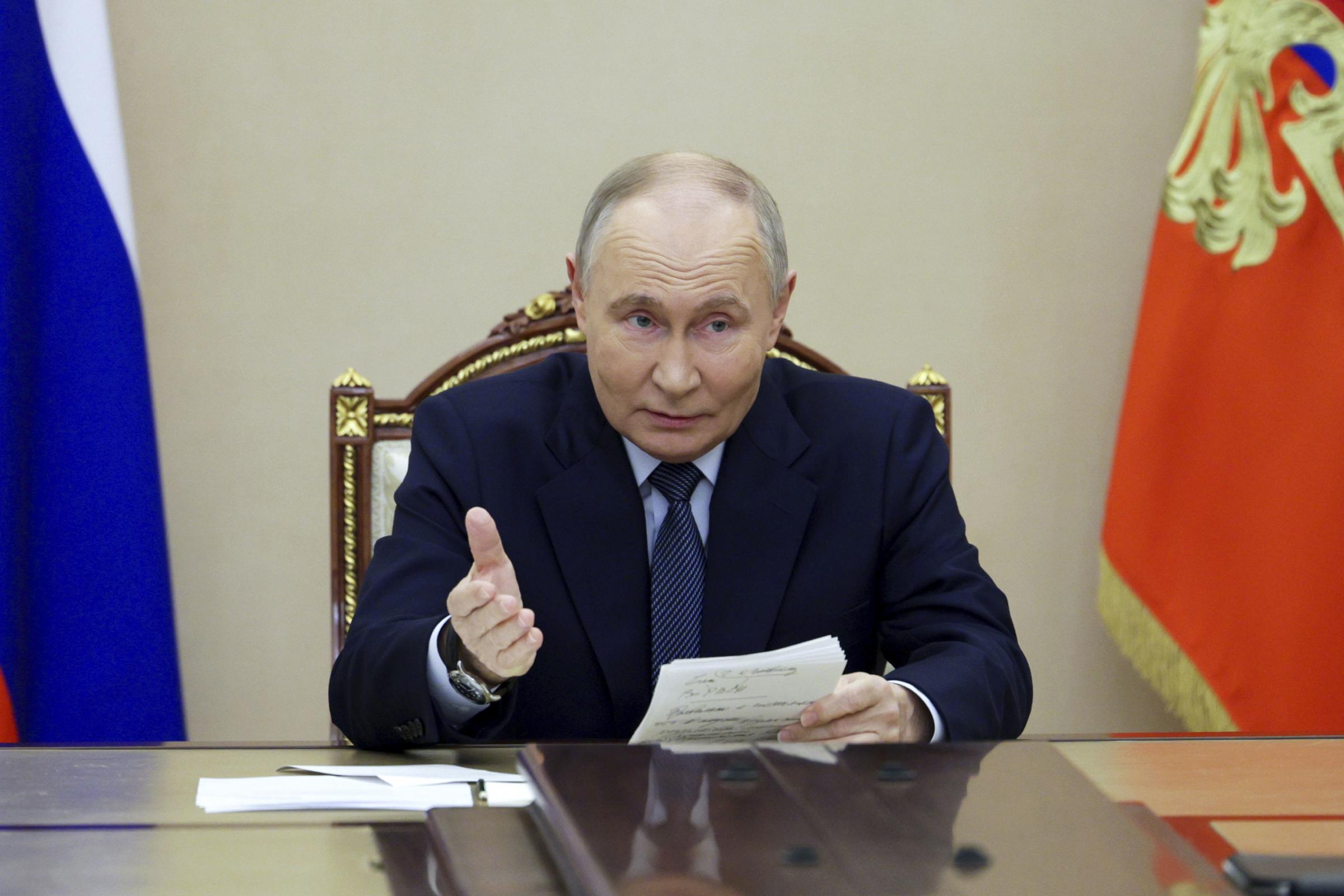 Russian President Vladimir Putin gestures as he speaks during a meeting with the leadership of the Russian Ministry of Defense, representatives of the military-industrial complex and developers of missile systems at the Kremlin in Moscow, Russia, Friday,