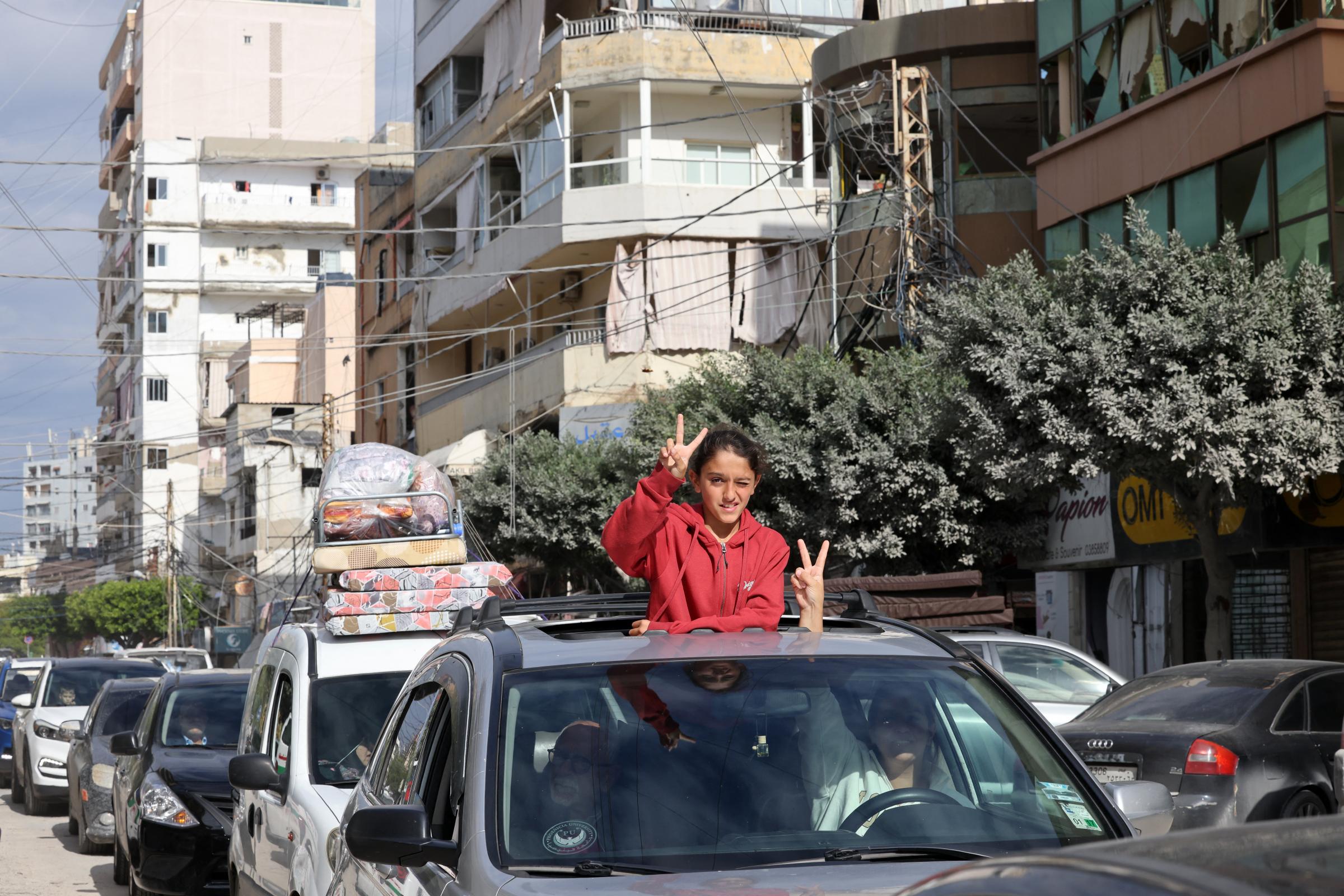 Residents who had fled the southern Lebanese city of Tyre, flash the victory sign upon their return on November 28, 2024, a day after a ceasefire between Israel and Hezbollah took hold. Since the ceasefire took effect on November 27, tens of thousands of